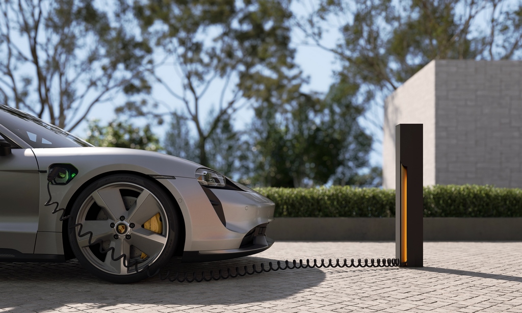 An electric car is charging in the driveway.